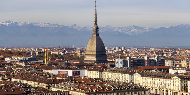 Discover the stunning cityscape of Turin with the iconic Mole Antonelliana and the Alps in the background.