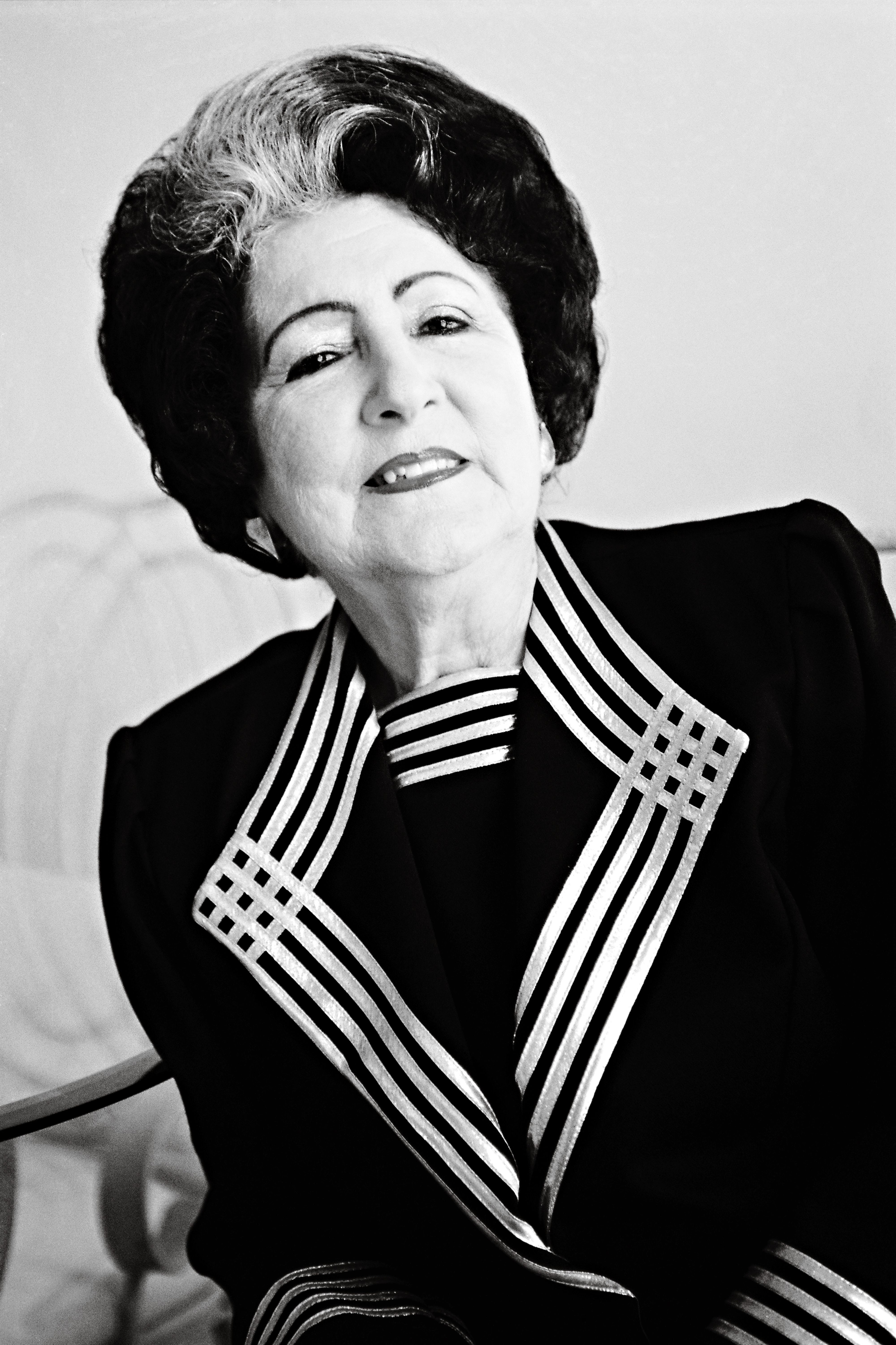 Classic black and white portrait of a senior woman in vintage attire.