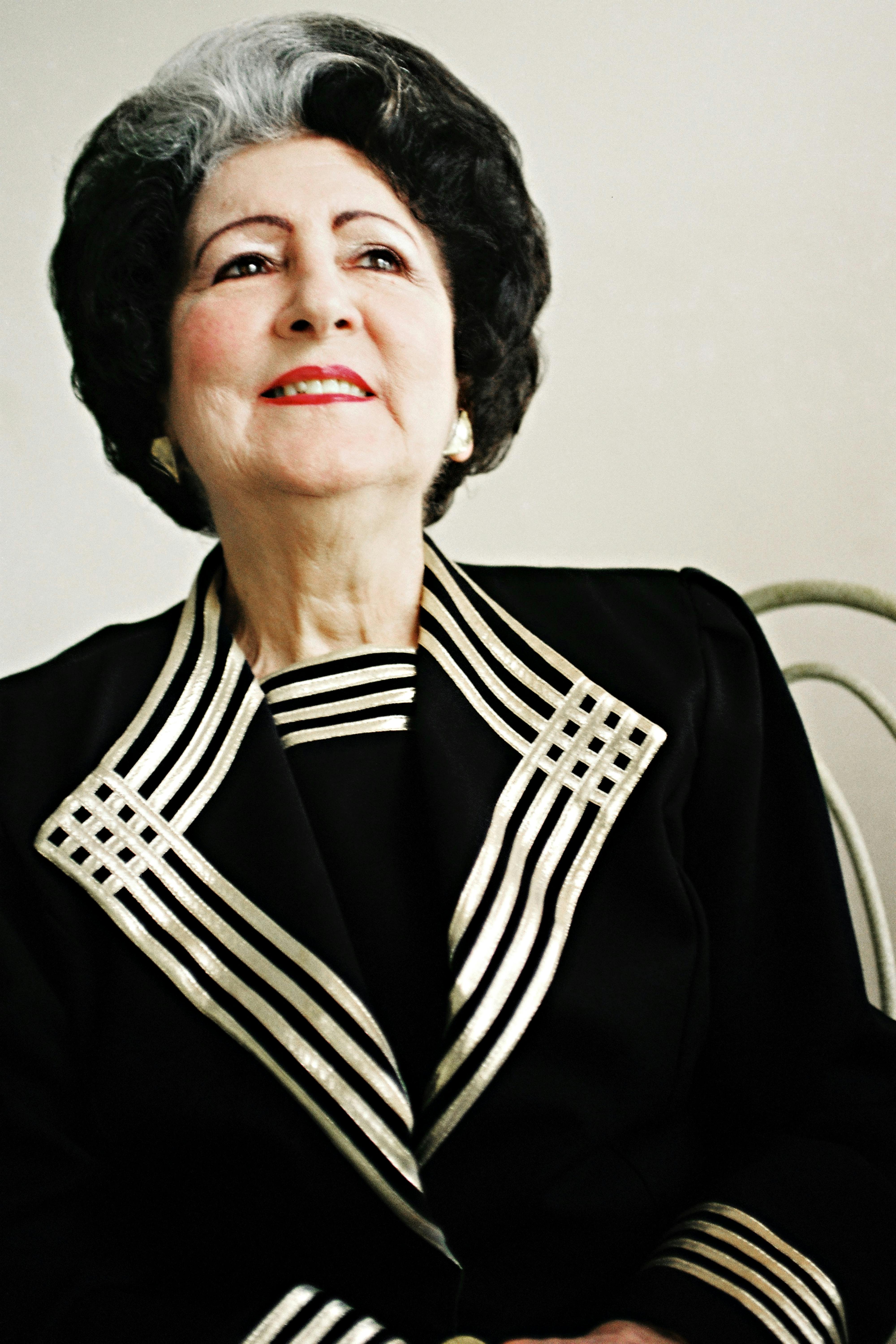 Portrait of a stylish elderly woman in a vintage outfit with silver highlights.