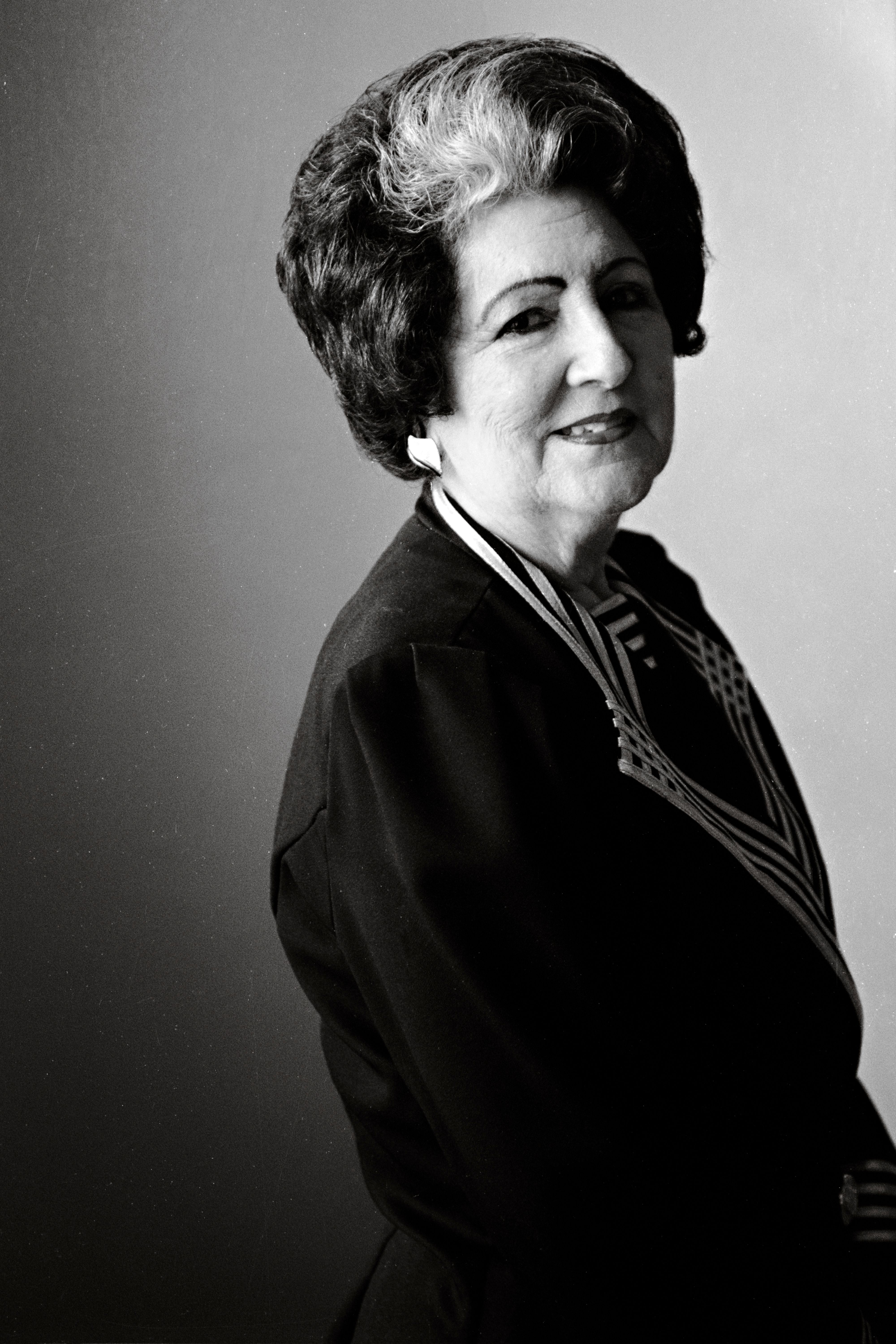 Classic black and white portrait of a mature woman in formal attire, showcasing timeless elegance.