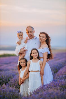 Multigenerational family enjoying a sunset in a lavender field, embracing together.