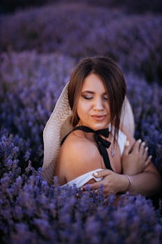 Graceful woman in hat among vibrant lavender blooms, exuding calm and elegance.