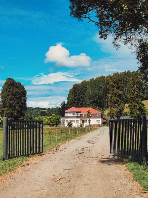 Free Beautiful rural house in Chile surrounded by lush greenery under a vibrant blue sky. Stock Photo