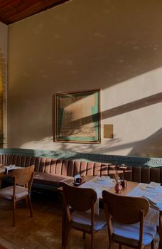Charming café interior with sunlit walls and tasteful art piece displaying warmth and elegance.