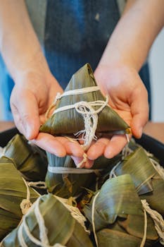 Close-up of homemade Japanese rice dumpling wrapped in bamboo leaf, showcasing detailed craftsmanship.