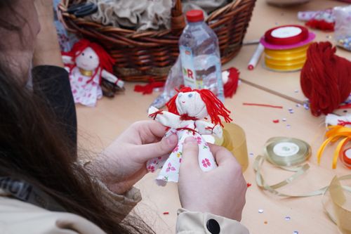 Free Person crafting a floral dress rag doll using colorful materials and threads. Stock Photo