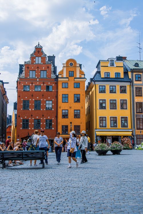 Free Colorful historic buildings in Gamla Stan, Stockholm on a sunny day, with people enjoying the square. Stock Photo