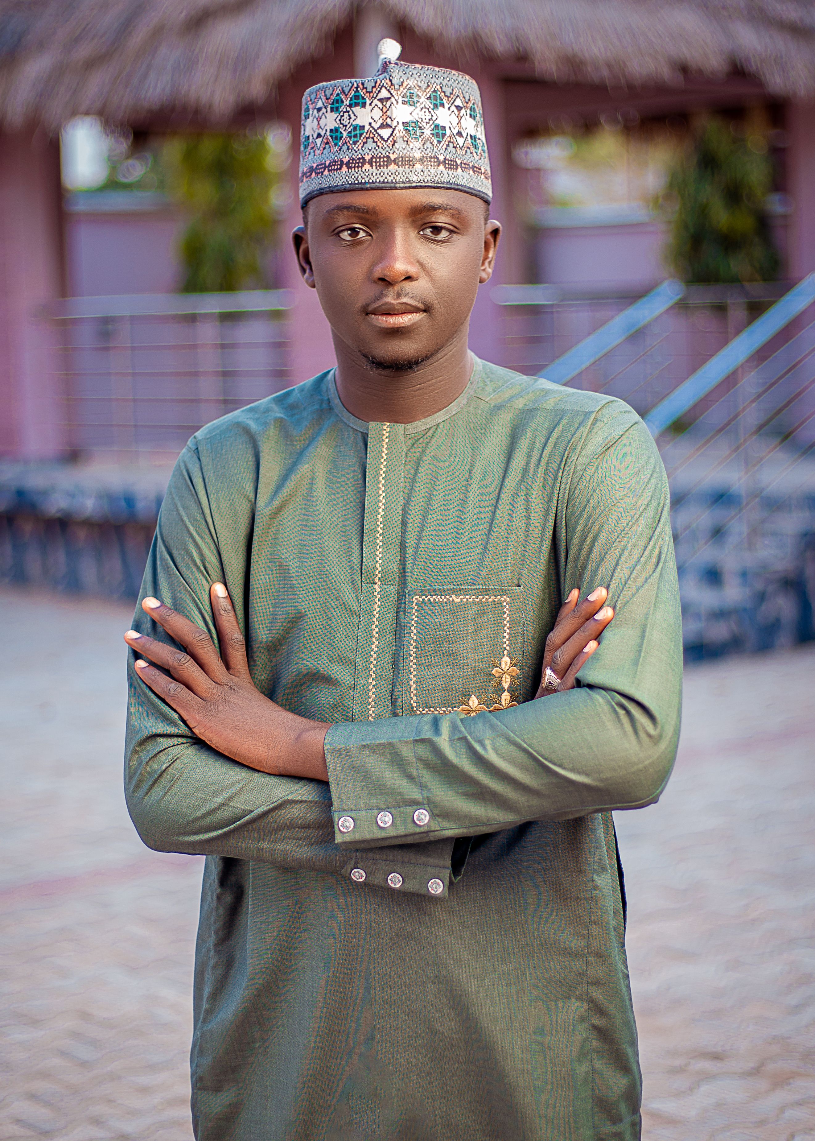 Confident young man in green traditional African attire outdoors, showcasing fashion and culture.