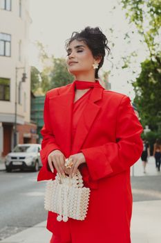 Woman in red outfit posing confidently in an urban Moscow street.