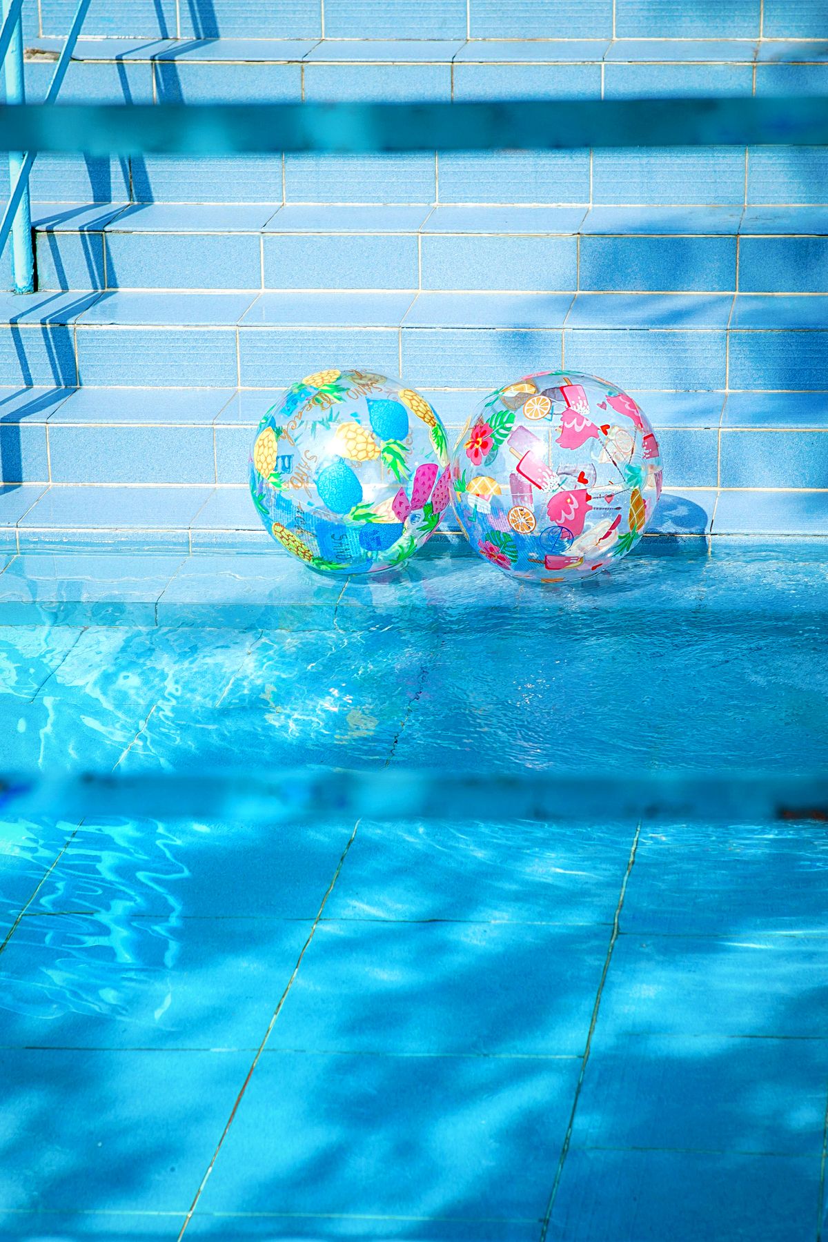 Colorful beach balls floating in a pool during pool party games