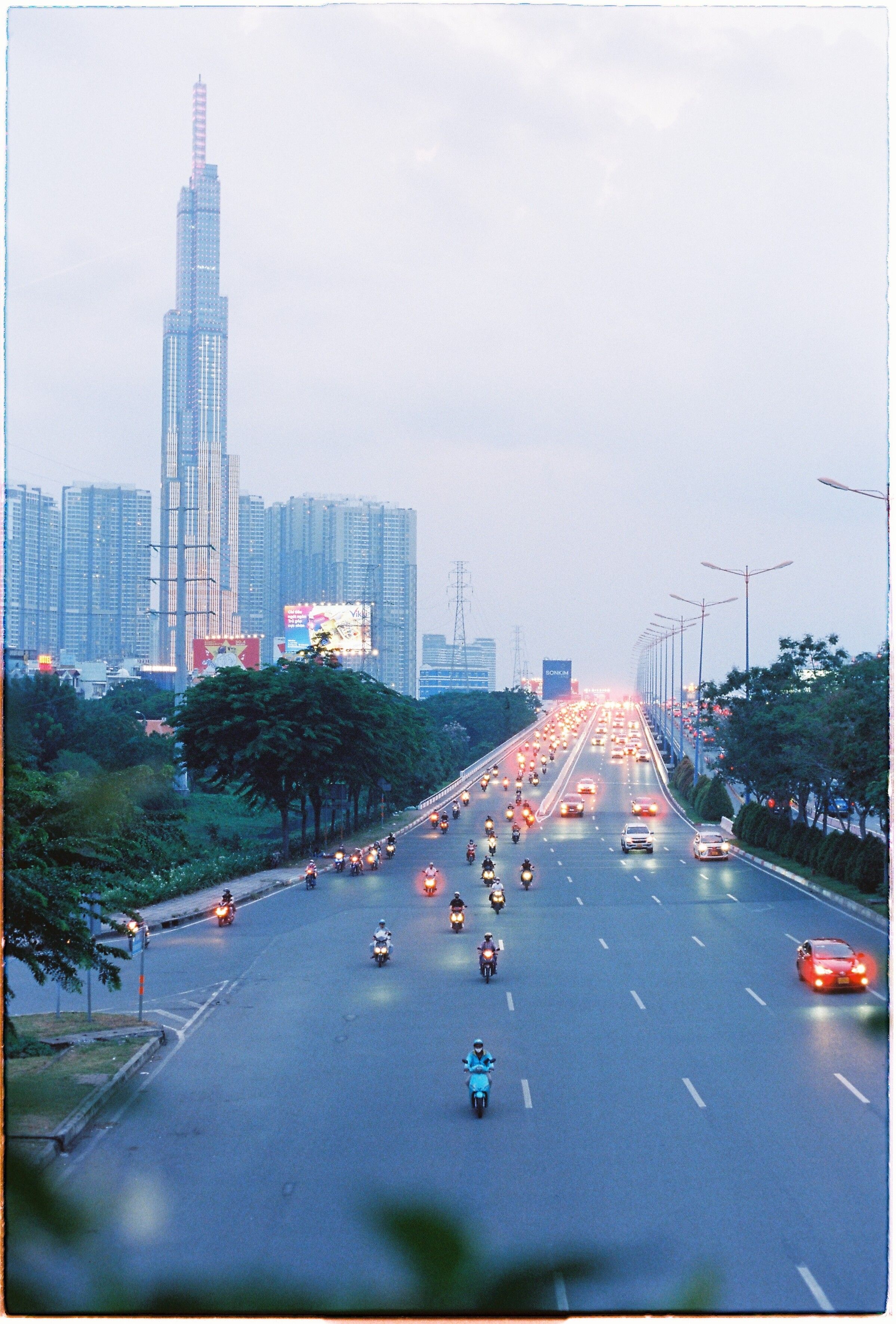 A vibrant cityscape with traffic and skyscraper, captured at dusk.