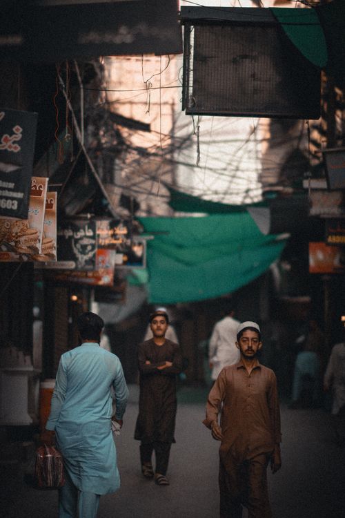 Free Street scene in Peshawar depicting daily life with vendors and traditional clothing. Stock Photo