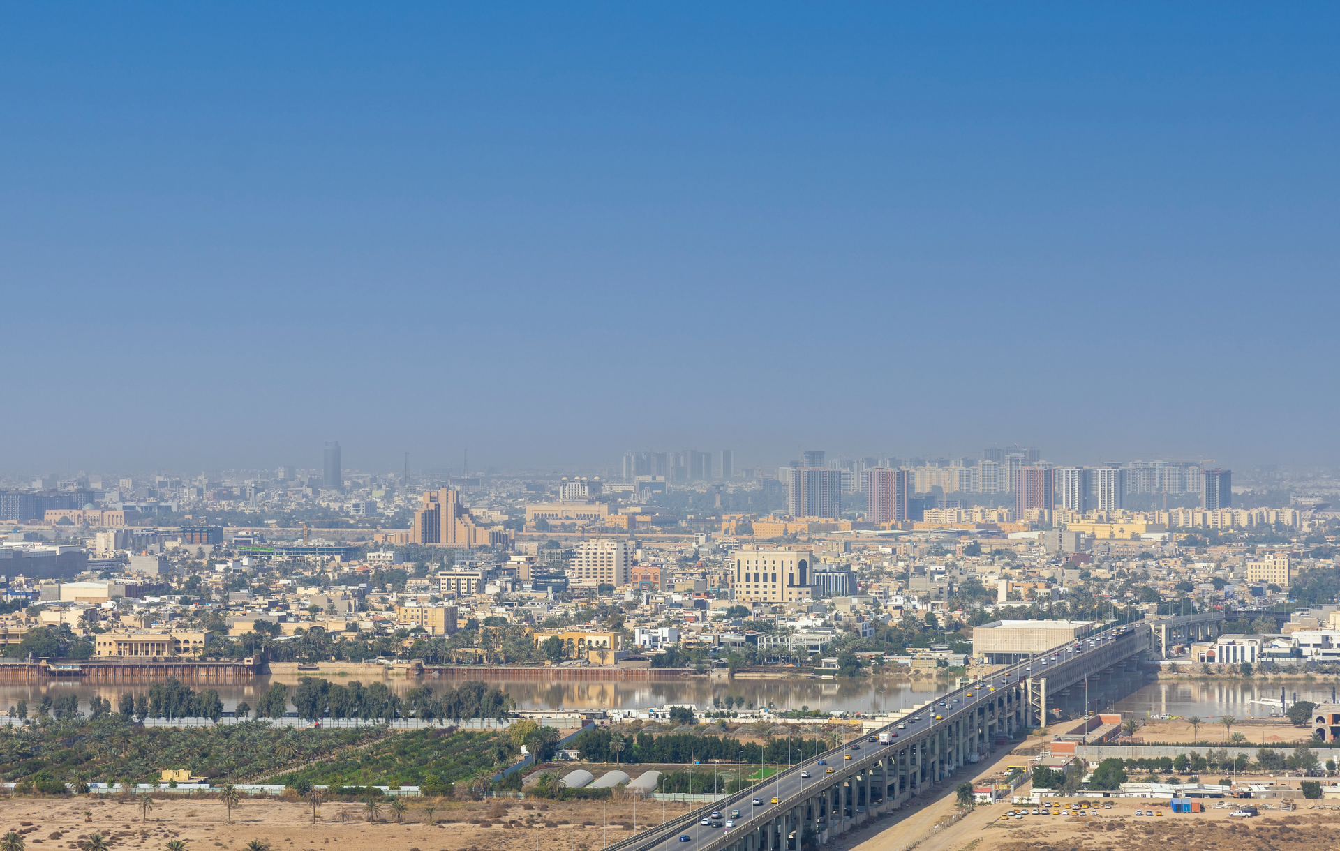 Breathtaking aerial view of Baghdad cityscape with Tigris River, showcasing urban architecture.