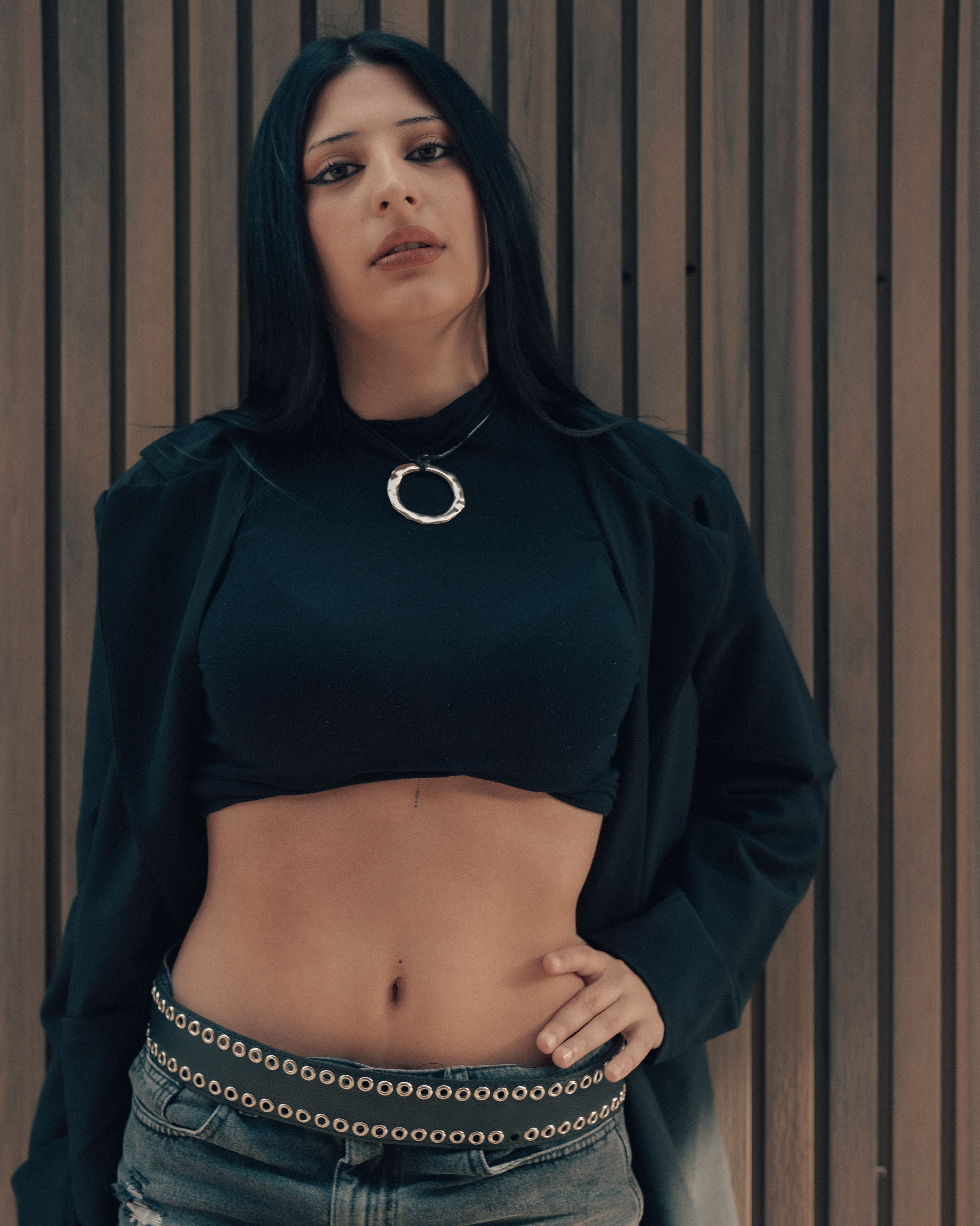 Portrait of a fashionable woman leaning against a wooden wall in Buenos Aires.