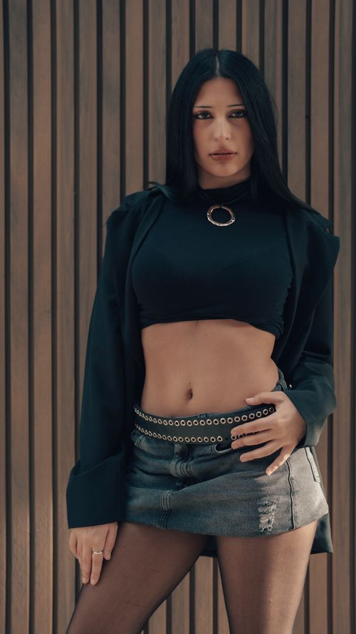 Free Fashionable woman posing confidently against a wooden backdrop in Buenos Aires. Stock Photo