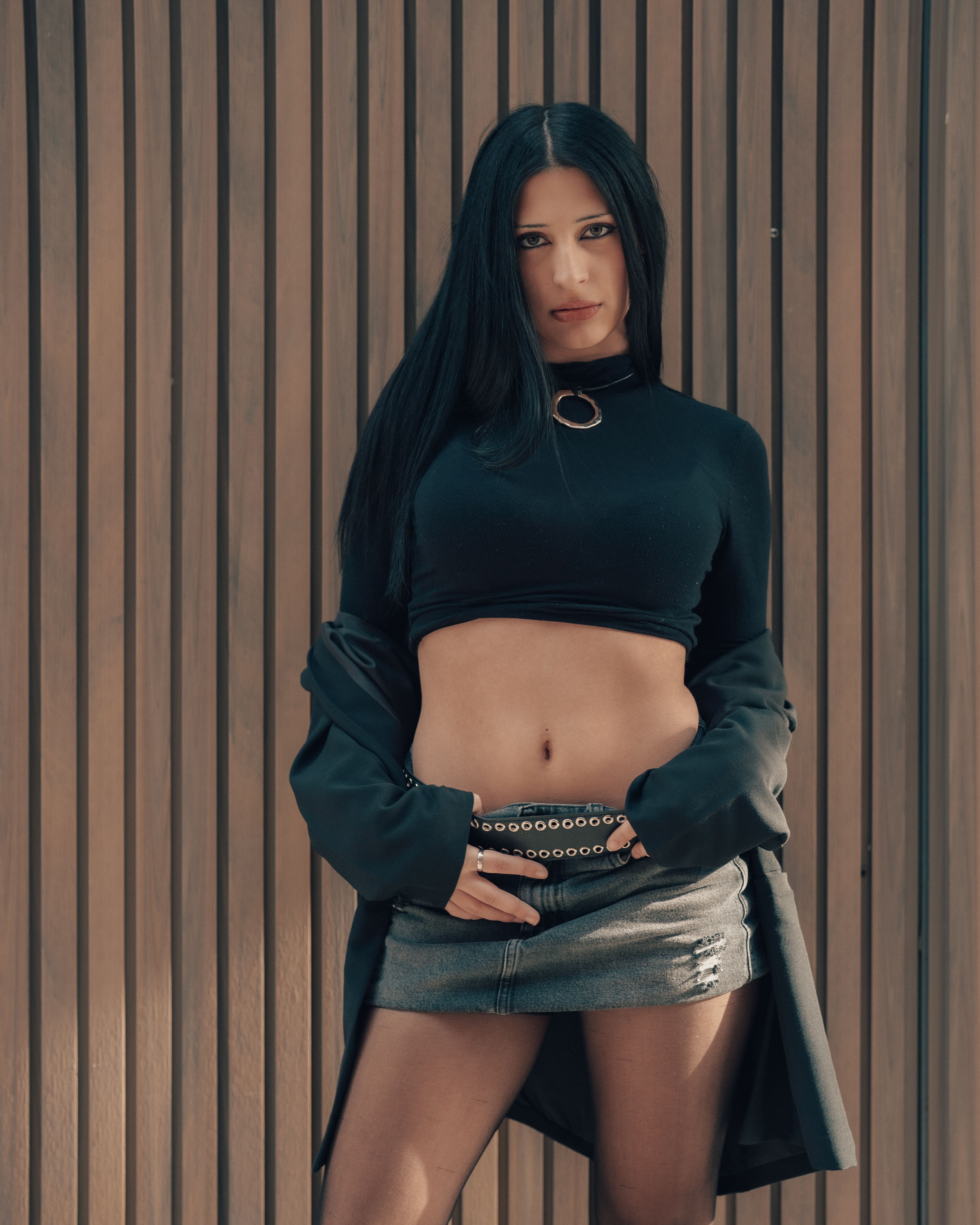 Stylish woman posing in trendy attire against a wooden backdrop in Buenos Aires.