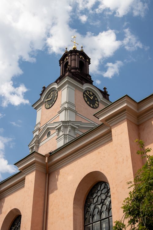 Free View of a historic church tower in Stockholm, Sweden against a bright blue sky. Stock Photo