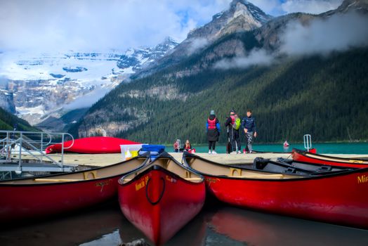 Vibrant canoes at Lake Louise with breathtaking snowy mountains in the background.