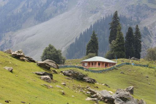 Free Beautiful mountain scene featuring a lone house surrounded by lush greenery. Stock Photo