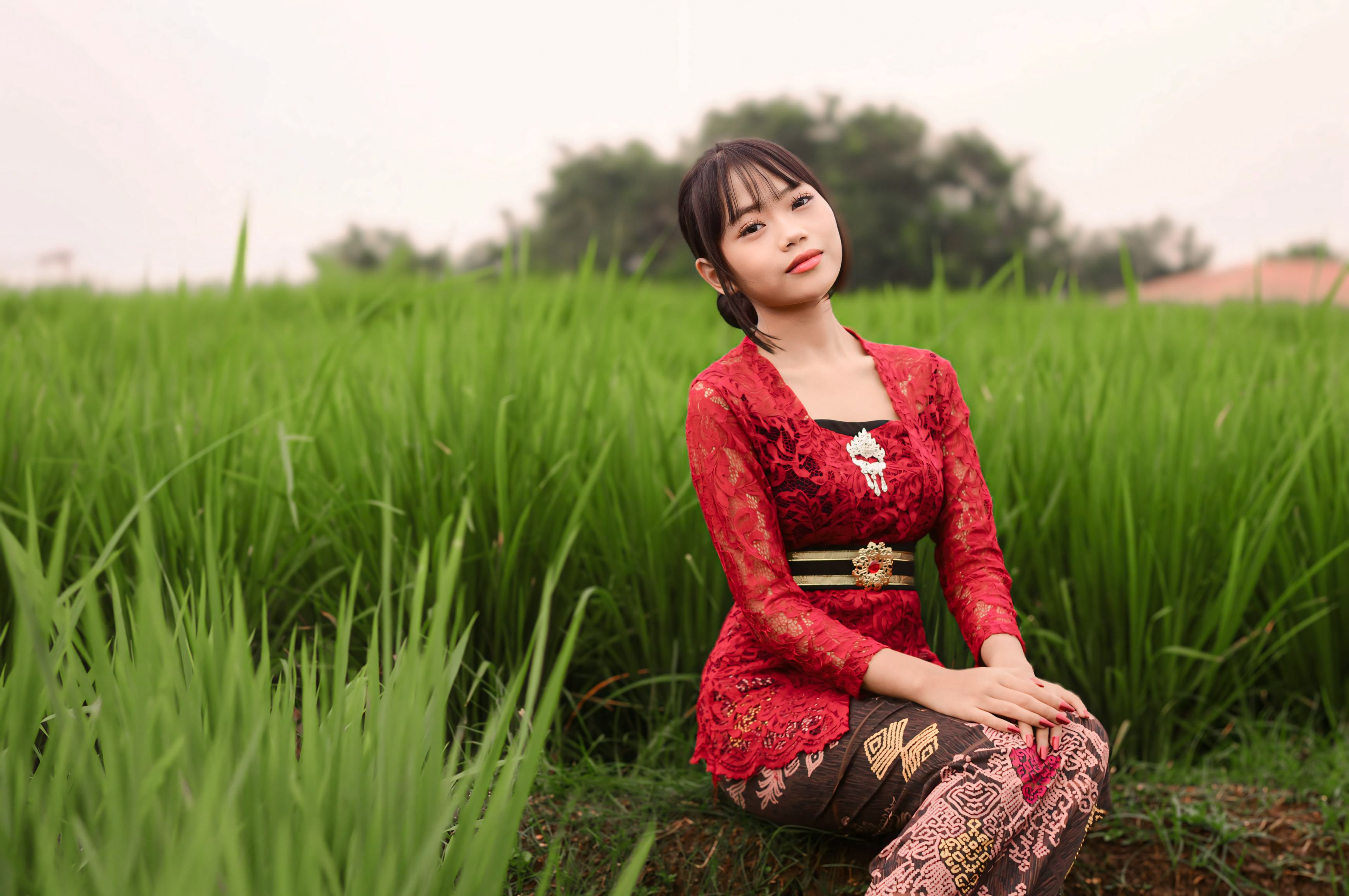 Young Woman in Traditional Dress in Lush Green Field