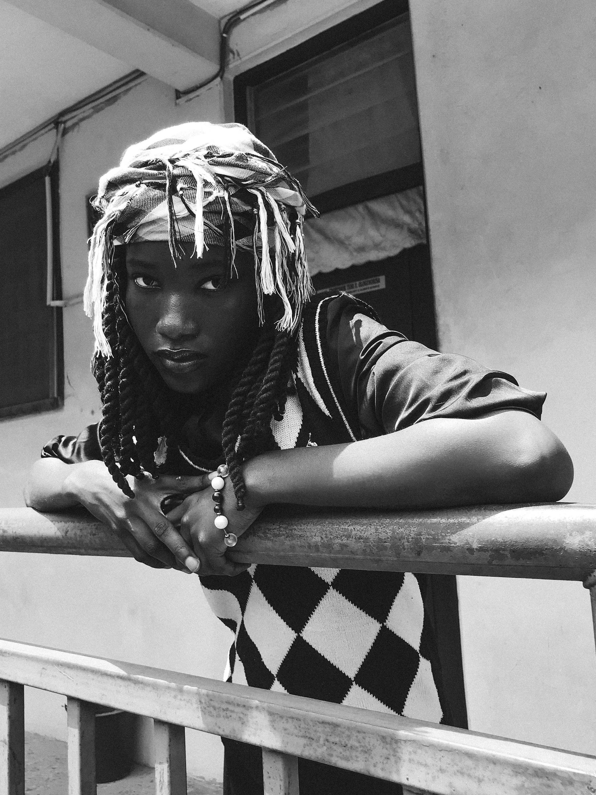 A moody black and white portrait of a person leaning on a railing, embodying street style.