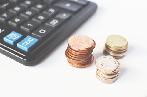 Free Gold-colored Coins Near Calculator Stock Photo