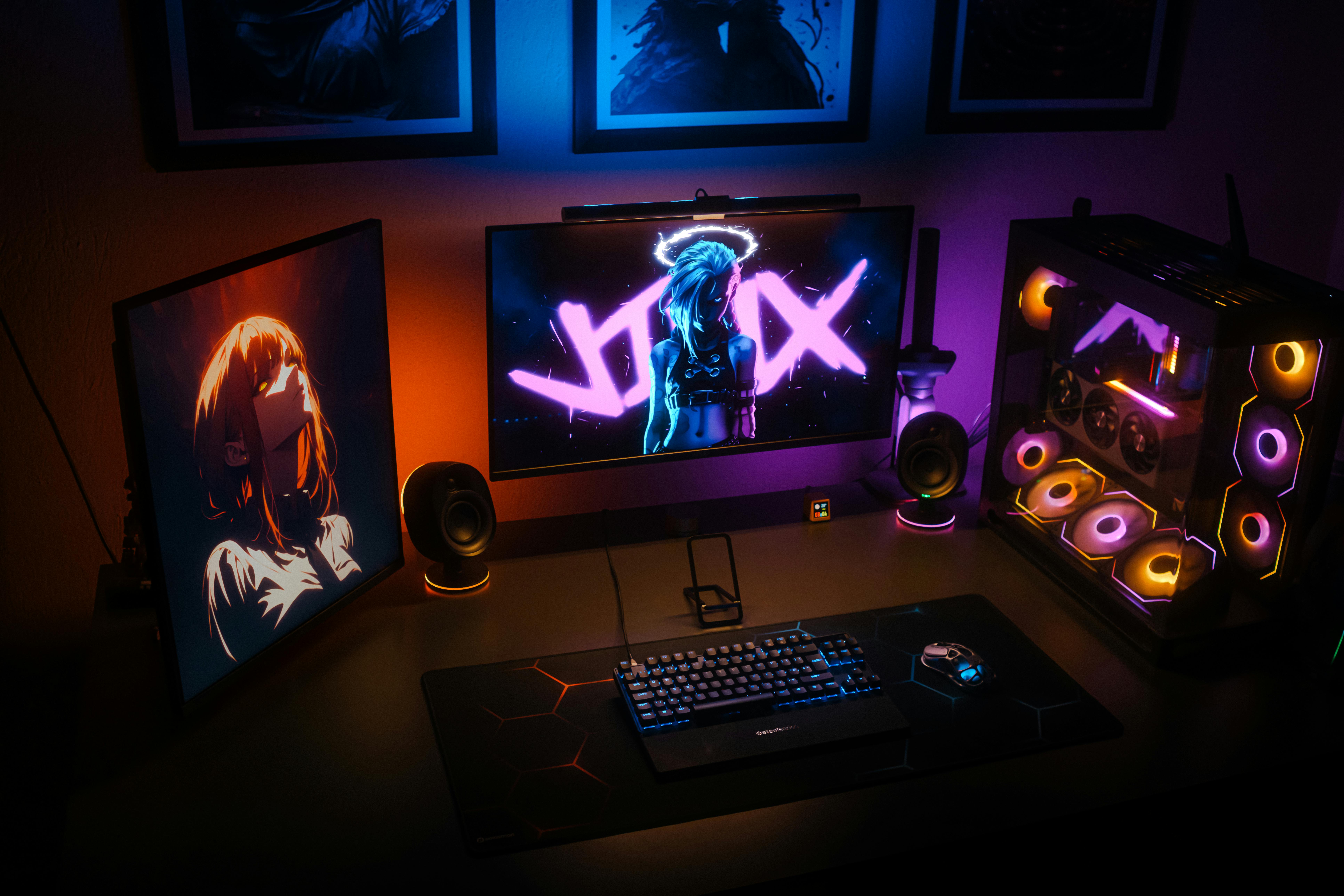 Free A modern gaming setup featuring RGB lighting, dual monitors, and a custom PC with colorful components. Stock Photo