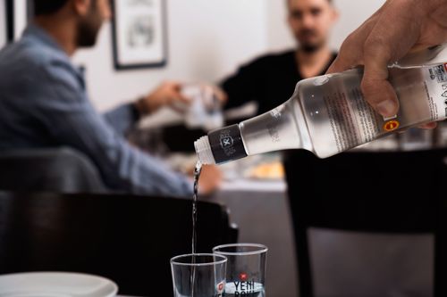 Free A close-up of raki being poured into glasses during a meal in an Istanbul restaurant setting. Stock Photo