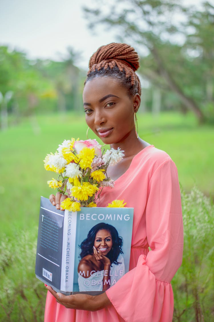 Woman Carrying A Bouquet Of Flowers And A Book