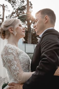 Bride and groom sharing a romantic moment outdoors at sunset.