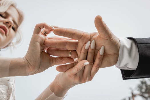 Intimate close-up of a couple exchanging rings at their wedding ceremony.