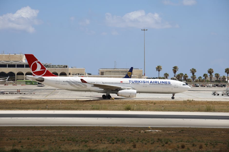 Turkish Airlines airplane taxiing on a sunny airport runway with clear skies.