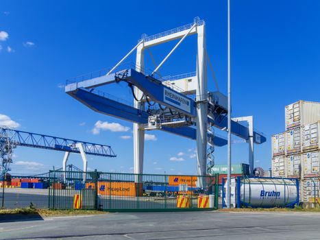 Large cargo crane at Rheinhafen port in Krefeld, Germany under a clear blue sky.