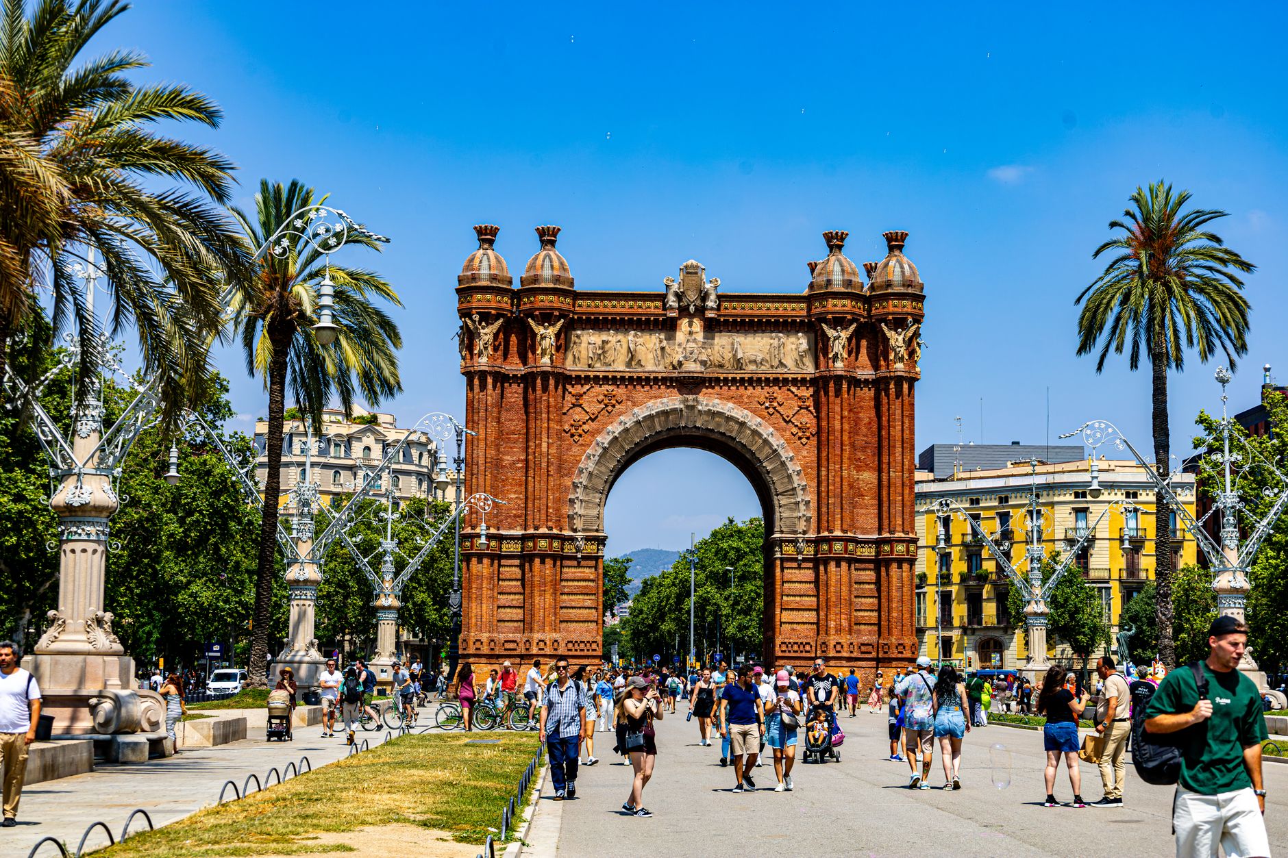 A bustling scene at Arc de Triomf, Barcelona, showcasing architecture and vibrant street life.