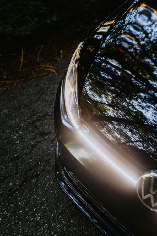Free Artistic shot of car headlight with tree reflections, showcasing sleek design and glossy surface. Stock Photo