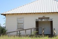 An old, white Baptist church with a metal roof and rustic charm.