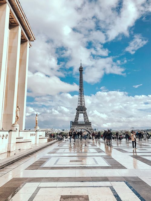 Free A scenic view of the Eiffel Tower in Paris with tourists on a sunny day. Captured from Trocadéro plaza. Stock Photo