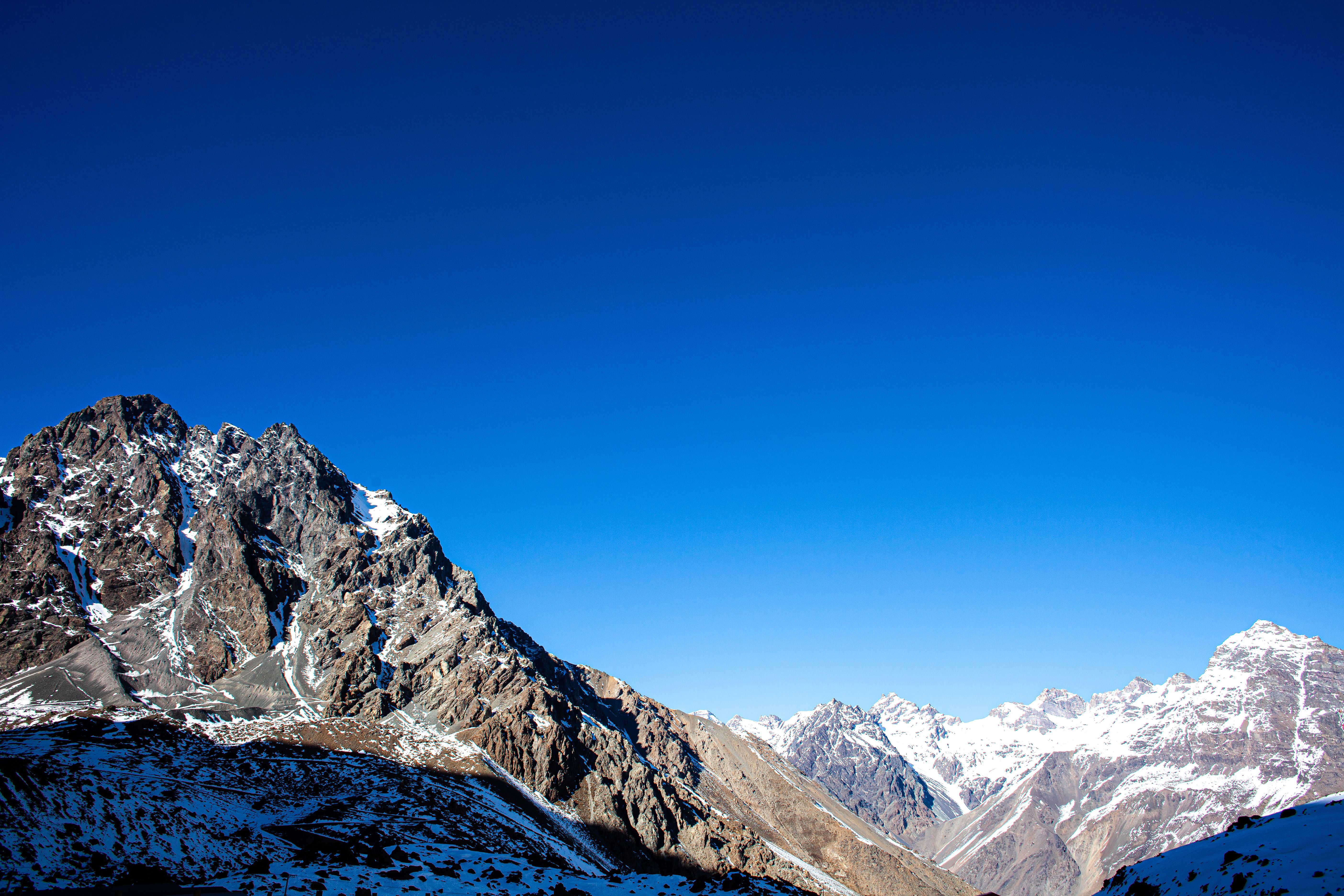 Stunning view of rugged snow-capped mountains with clear blue sky in the Andes.