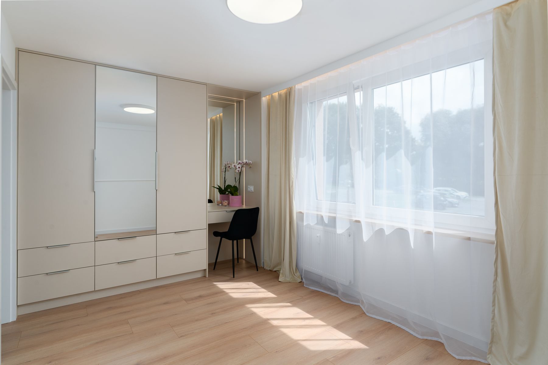 Bright bedroom with a clearly outlined bed, open floor and large window