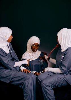 Three female healthcare professionals in uniforms with stethoscope. Medical setting.