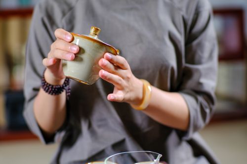 Free Elegant depiction of a traditional tea ceremony, focusing on the detailed hands holding a teapot indoors. Stock Photo
