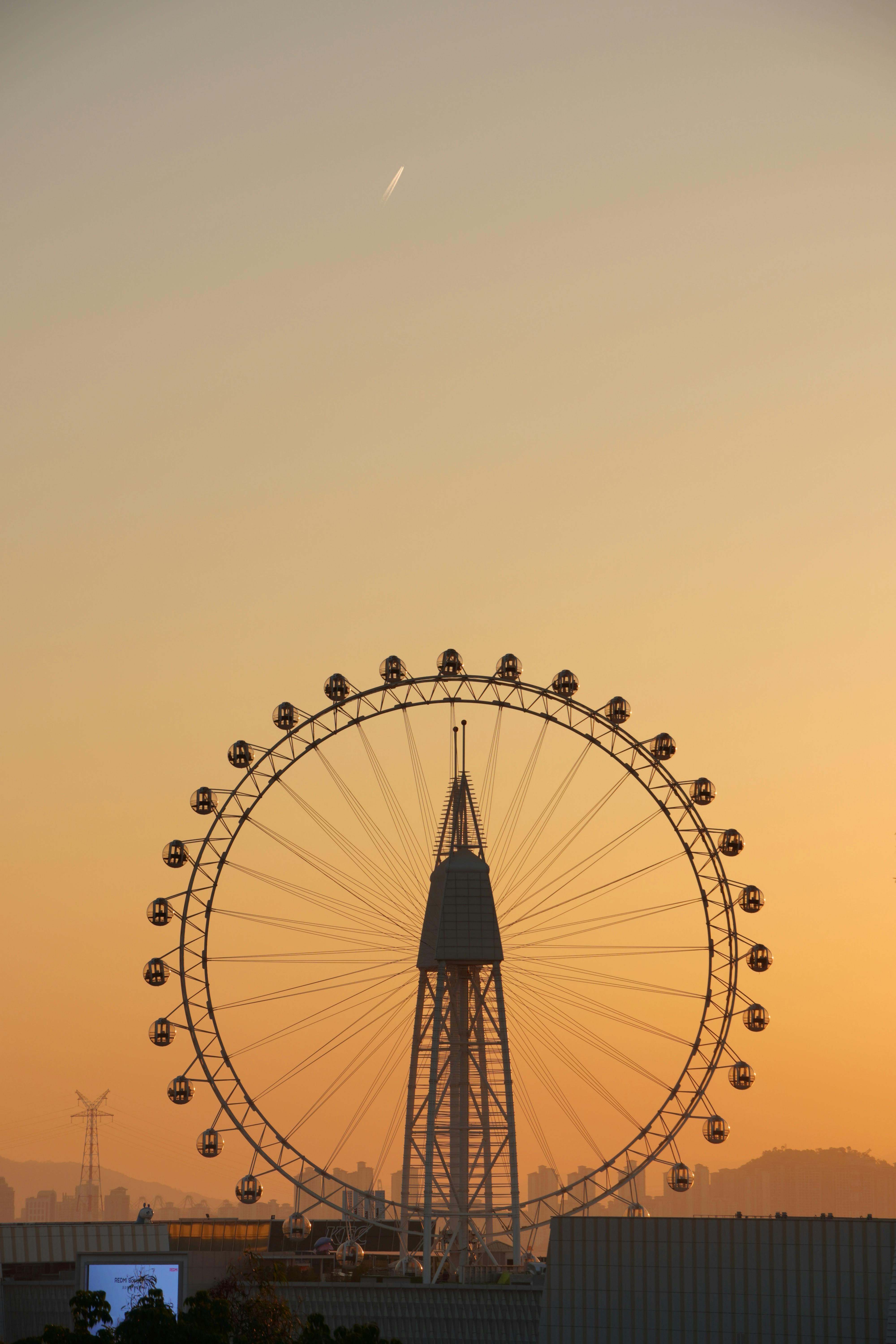 Ferris wheel frame against a serene sunset sky, evoking tranquility.