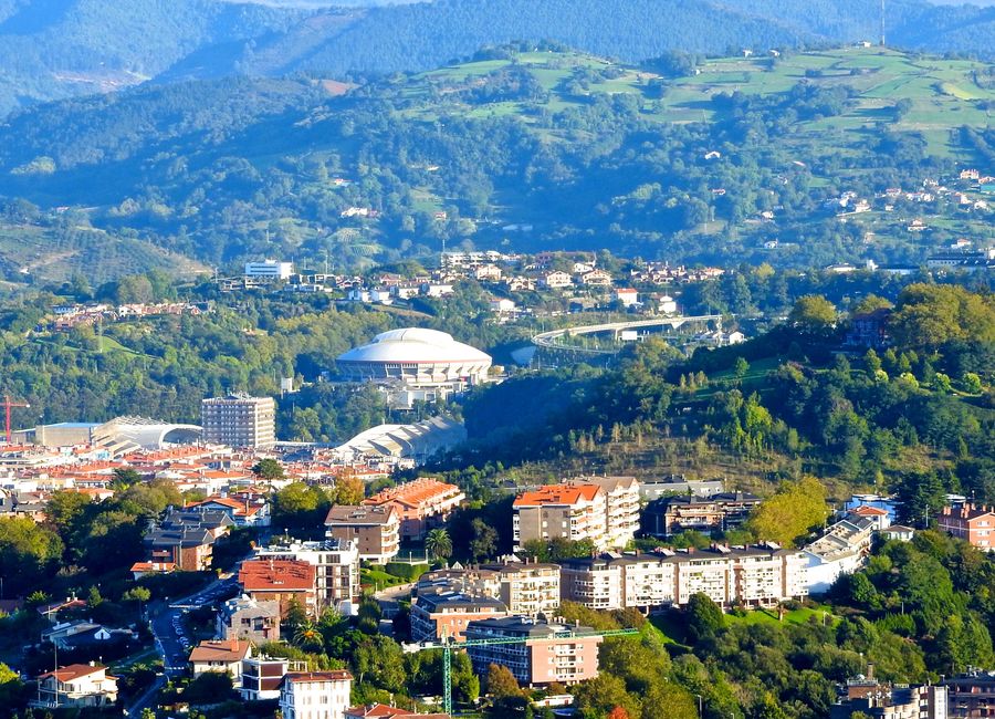 Aerial view of Donostia-San Sebastián with scenic hills and city buildings.