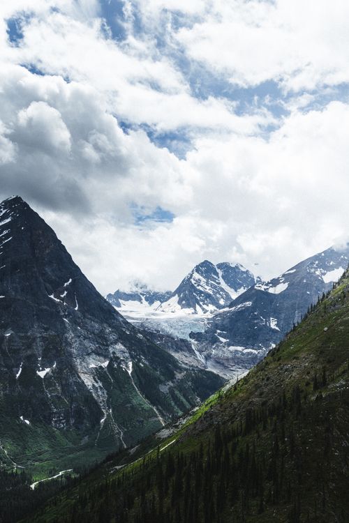 Free Beautiful mountain landscape with snow-capped peaks and dramatic clouds. Stock Photo