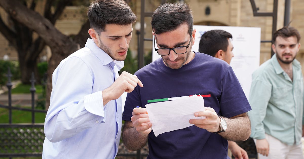 A group of adults engaged in discussion, analyzing documents outdoors in a park setting.