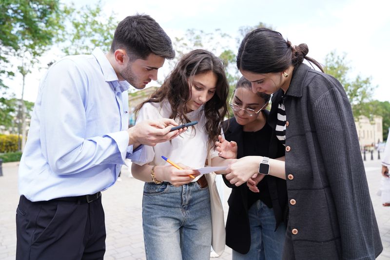Group of young adults discussing and collaborating in an outdoor setting