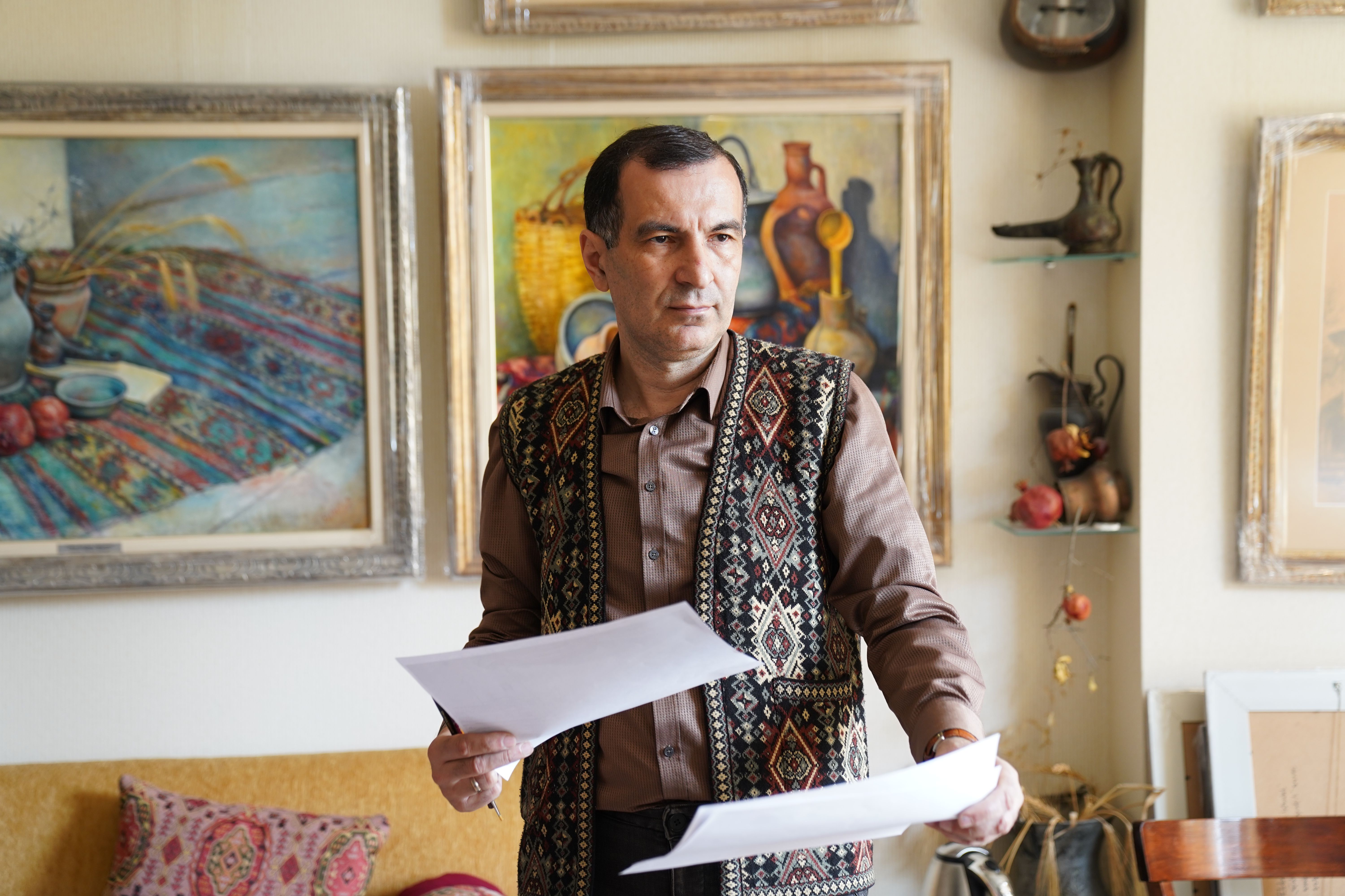 Man in Art Studio Holding Papers