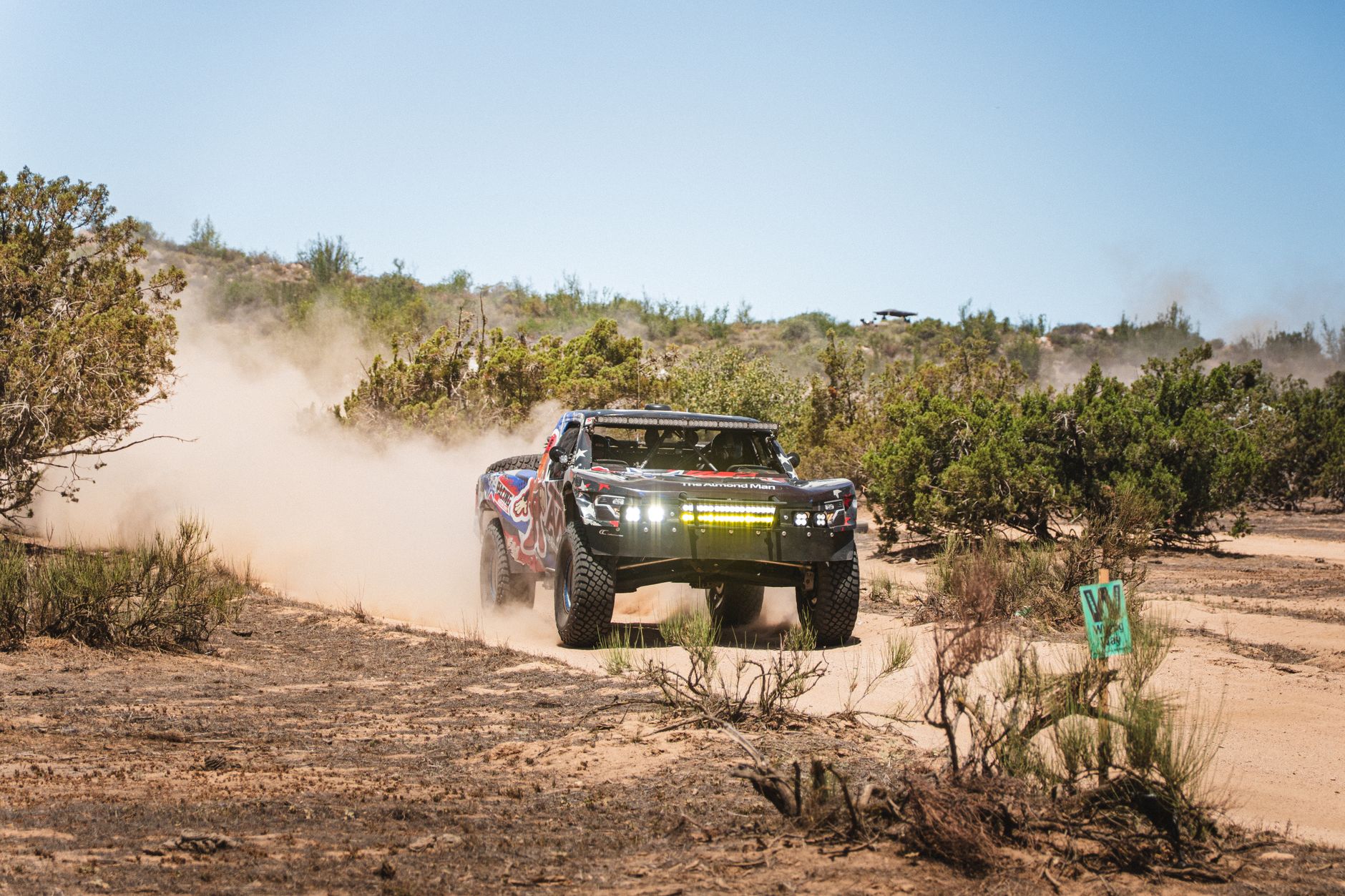 Off-road 4x4 truck kicking up dust on a desert trail during a trail day run