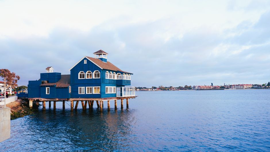 A picturesque blue building on stilts in San Diego's Seaport Village, captured at sunset.
