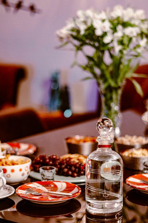 Free Luxurious dining setup with crystal decanter and flowers, creating a sophisticated ambiance. Stock Photo